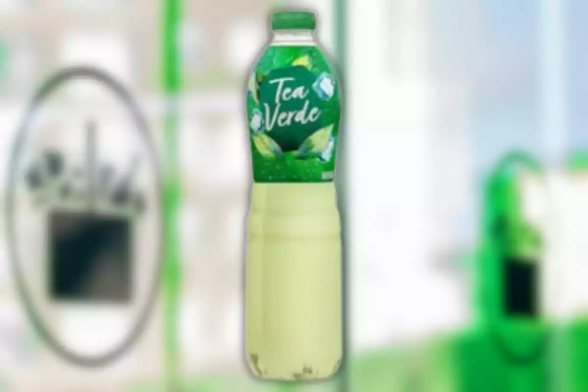Botella de té verde con etiqueta verde y hojas ilustradas sobre un fondo desenfocado Botella de té verde con etiqueta verde y hojas ilustradas sobre un fondo desenfocado