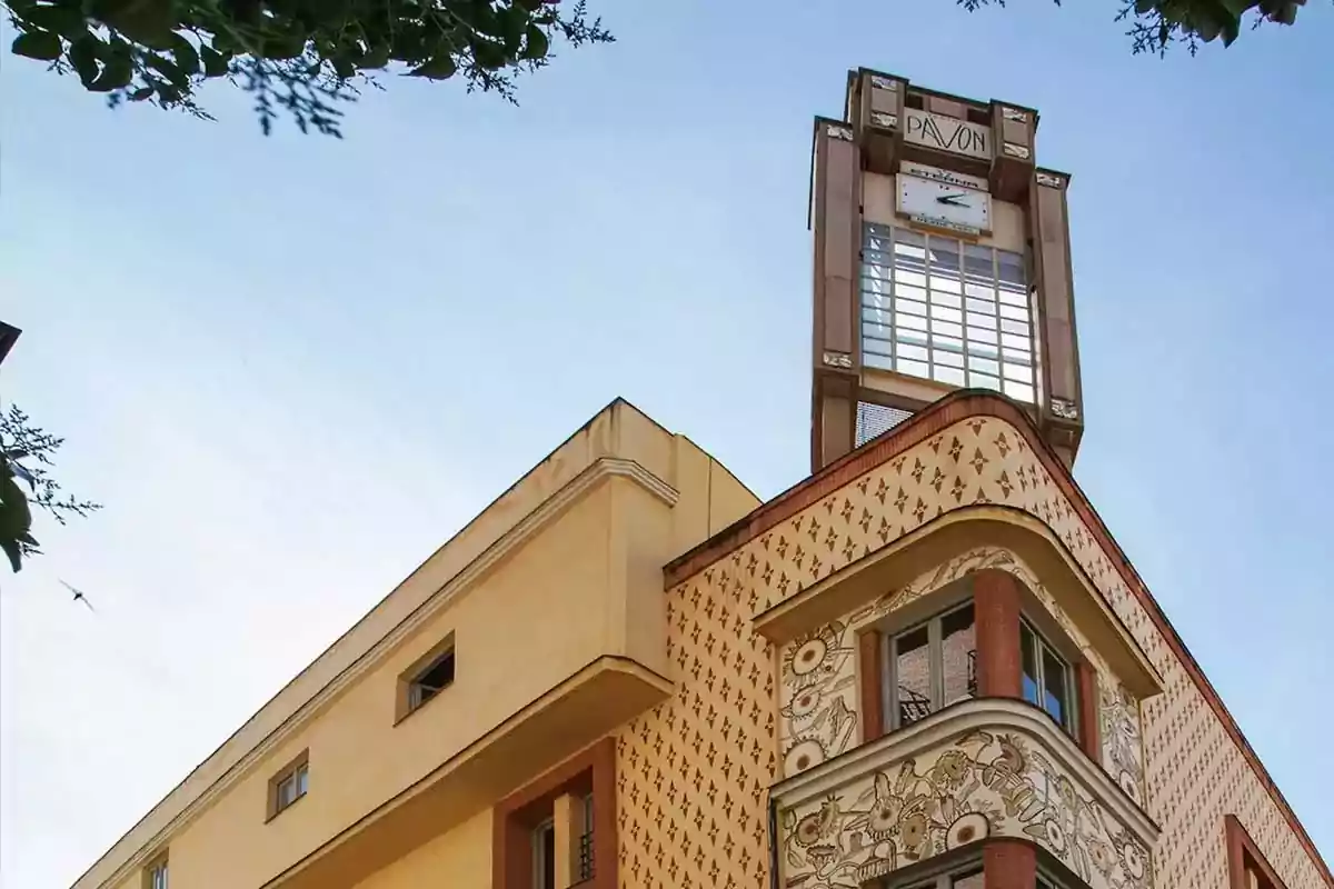 Edificio de estilo art déco con una torre de reloj en la parte superior, decorado con patrones geométricos y florales.