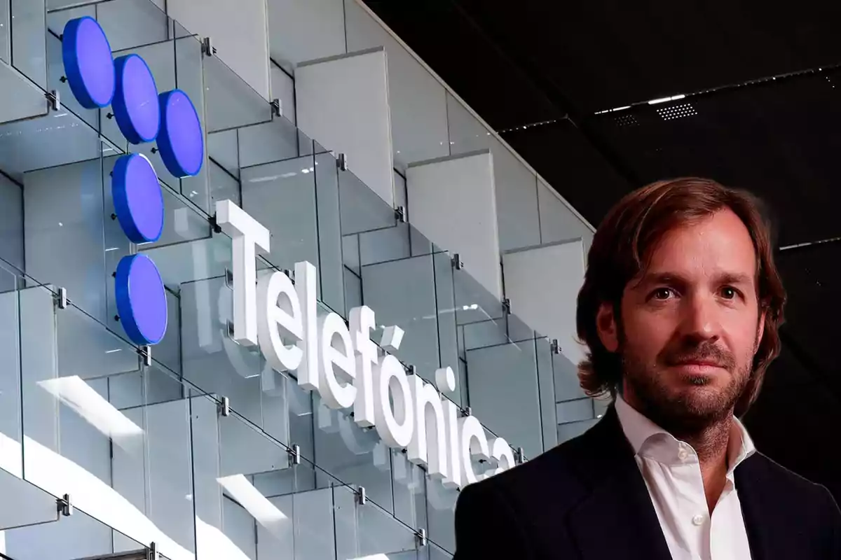 Un hombre de traje frente al logo de Telefónica en un edificio moderno.