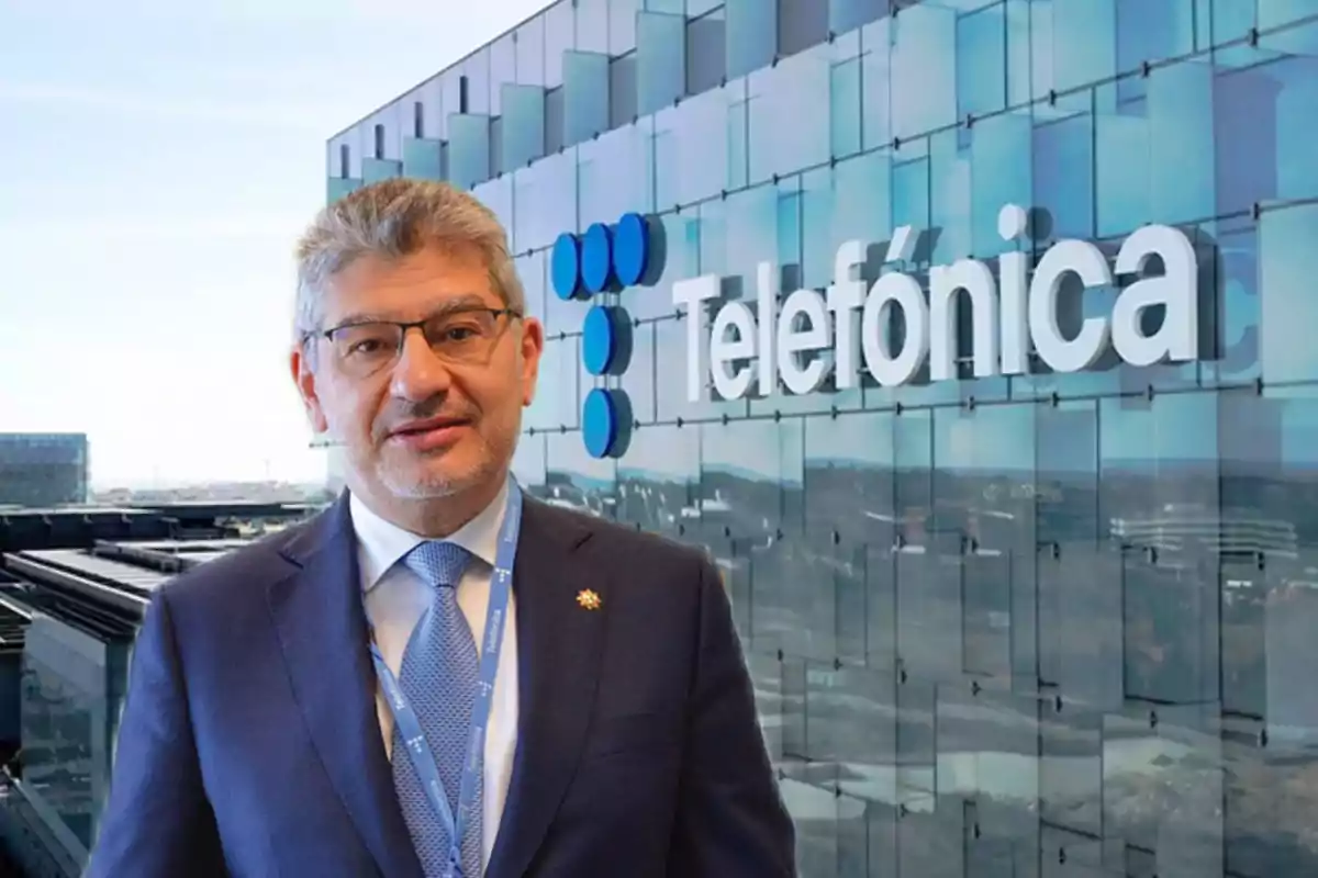 Un hombre con traje y corbata está frente a un edificio de oficinas con el logo de Telefónica.