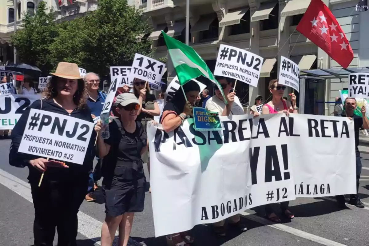 Personas manifestándose en la calle con pancartas y banderas, exigiendo cambios en la normativa para abogados y una jubilación digna