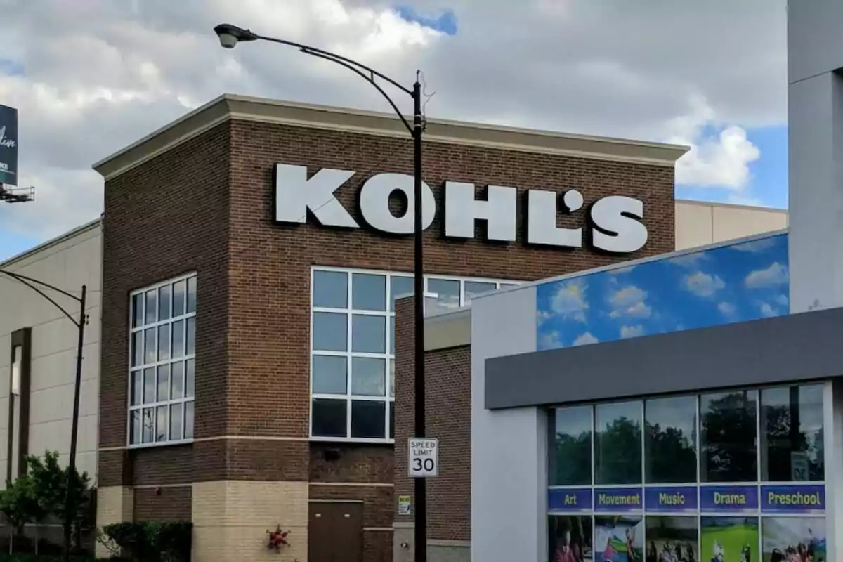 Edificio de una tienda Kohl's con un letrero grande en la fachada y un cartel de límite de velocidad en primer plano. Edificio de una tienda Kohl's con un letrero grande en la fachada y un cartel de límite de velocidad en primer plano.