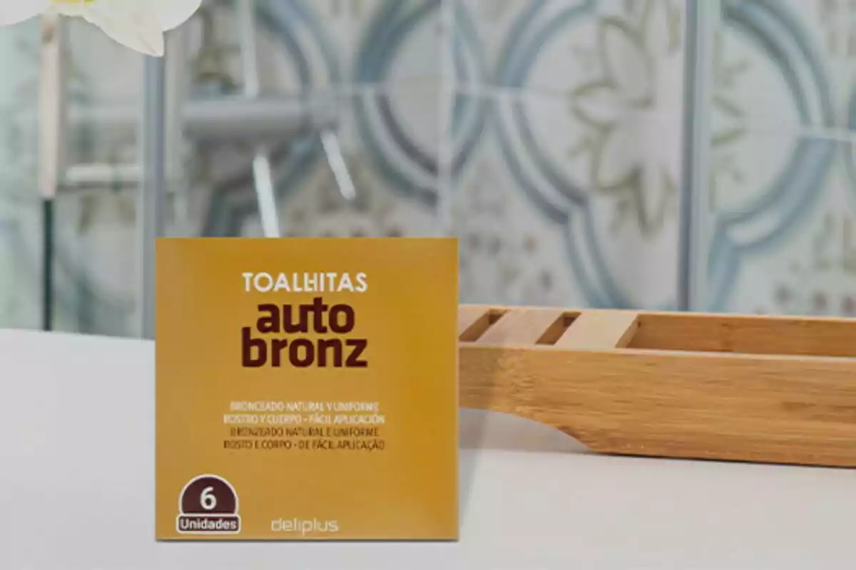 Una caja de toallitas autobronceadoras de la marca Deliplus está sobre una superficie blanca con un fondo desenfocado de azulejos decorativos. Una caja de toallitas autobronceadoras de la marca Deliplus está sobre una superficie blanca con un fondo desenfocado de azulejos decorativos.