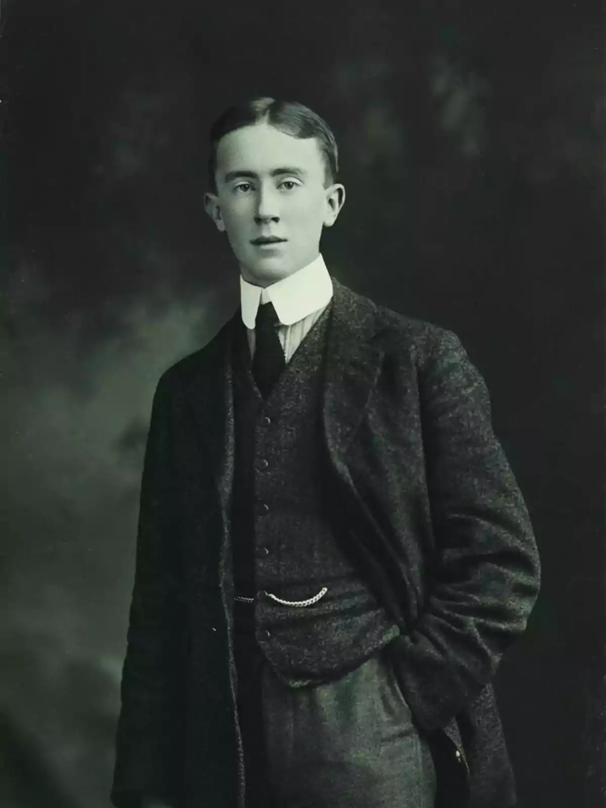 Joven con traje formal de principios del siglo XX en una fotografía en blanco y negro.