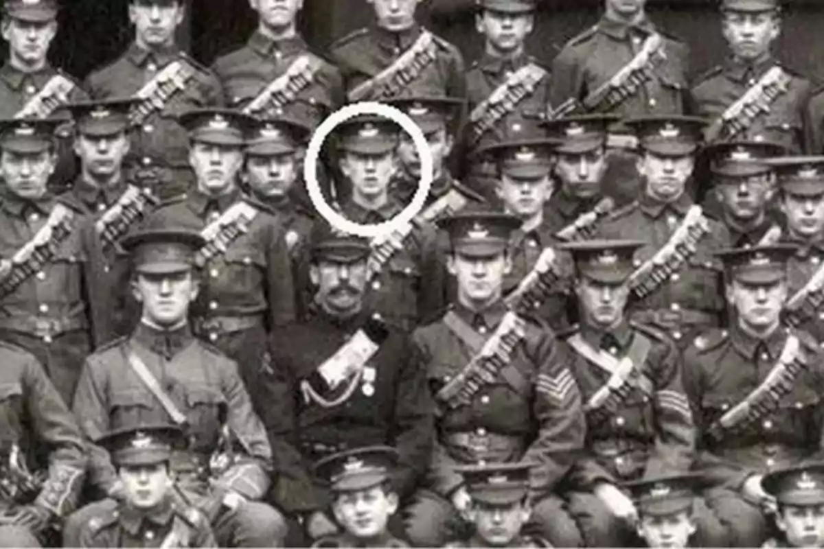 Un grupo de soldados posando para una fotografía en blanco y negro, con uno de ellos destacado con un círculo blanco alrededor de su cabeza.