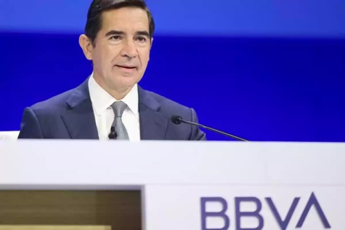 Hombre en traje hablando en una conferencia de BBVA.