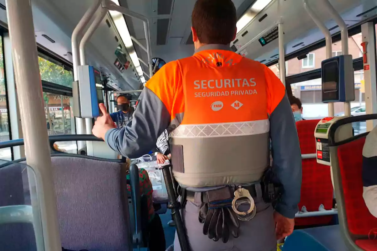 Un guardia de seguridad privada de pie en el interior de un autobús.