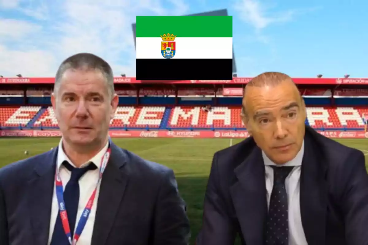 Dos hombres con traje en un estadio de fútbol con una bandera verde, blanca y negra con un escudo en el centro.