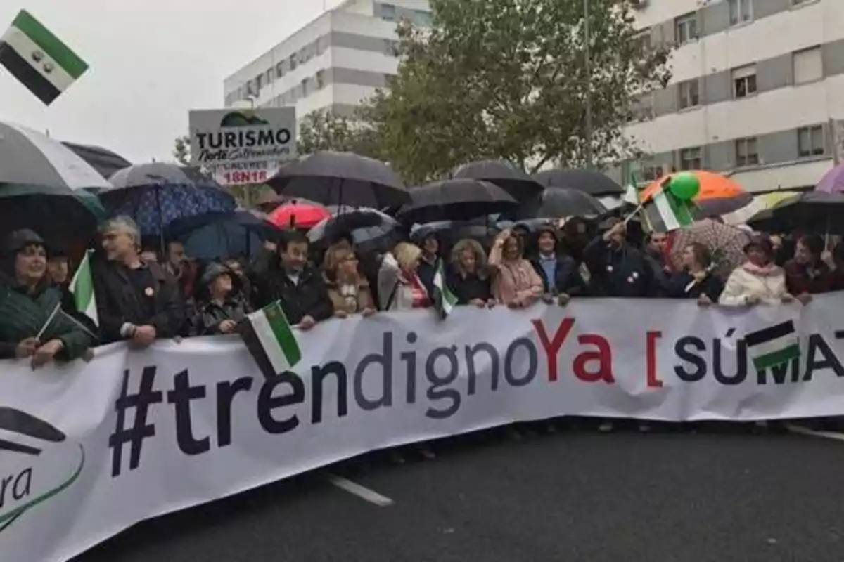 Personas bajo paraguas sosteniendo una pancarta que dice Personas bajo paraguas sosteniendo una pancarta que dice