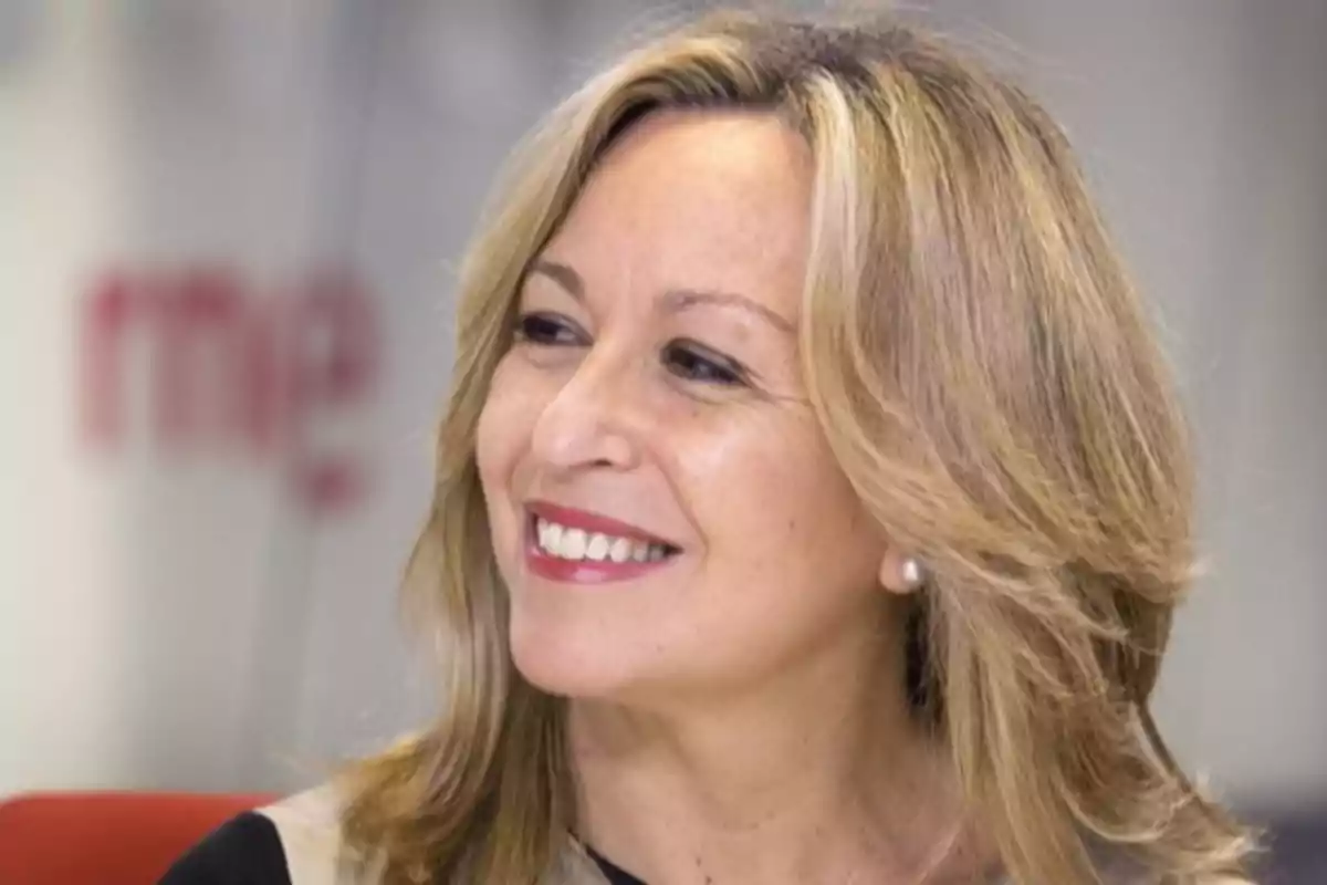 Mujer rubia de mediana edad sonriendo y mirando hacia la izquierda Mujer rubia de mediana edad sonriendo y mirando hacia la izquierda