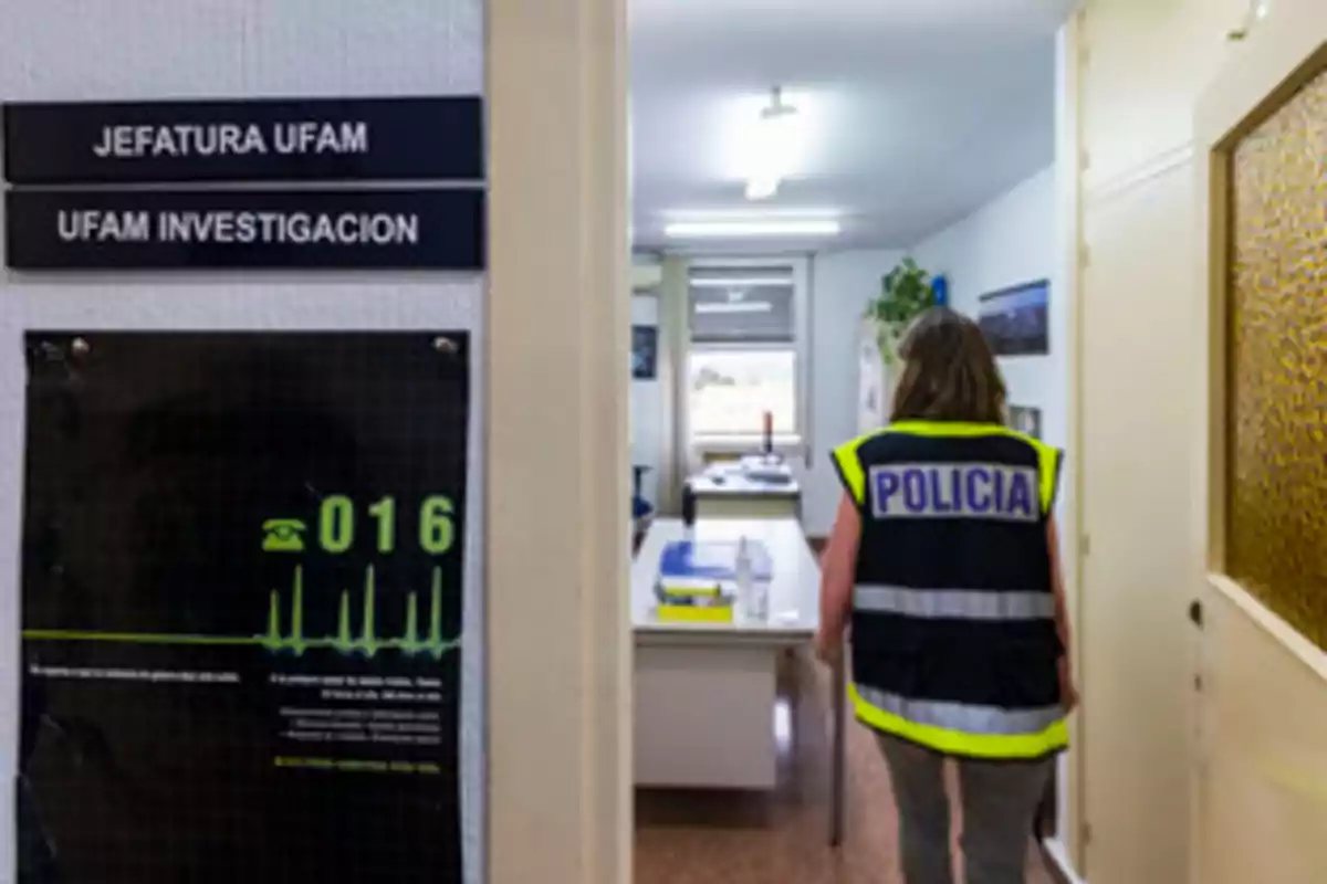 Oficina de la Jefatura UFAM con una agente de policía entrando.