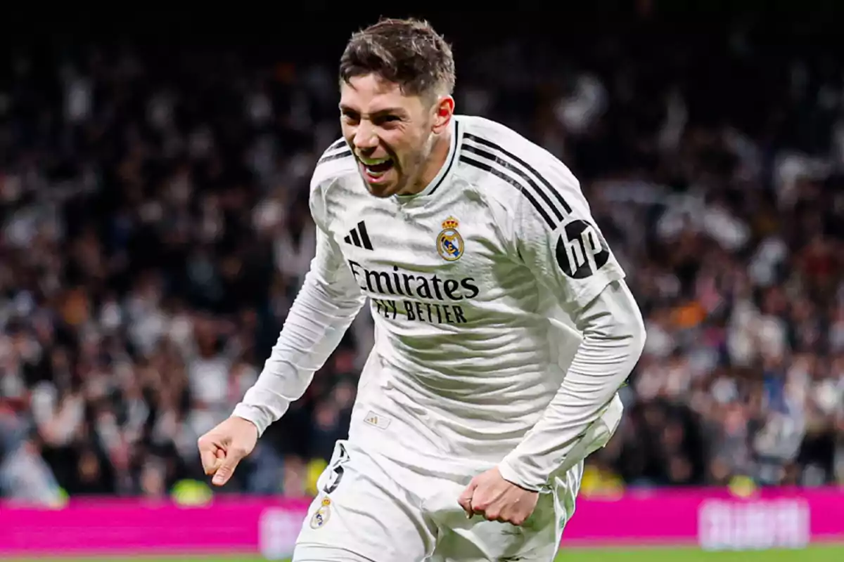 Un jugador de fútbol con uniforme blanco celebra en el campo durante un partido. Un jugador de fútbol con uniforme blanco celebra en el campo durante un partido.
