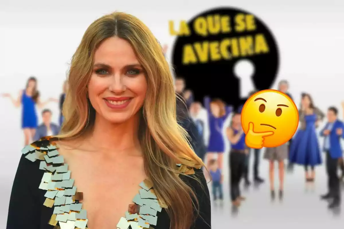 Vanesa Romero sonriente con cabello rubio y largo, vestida con un traje negro con detalles dorados, frente a un fondo borroso con el logo de "La Que Se Avecina" y un emoji pensativo.