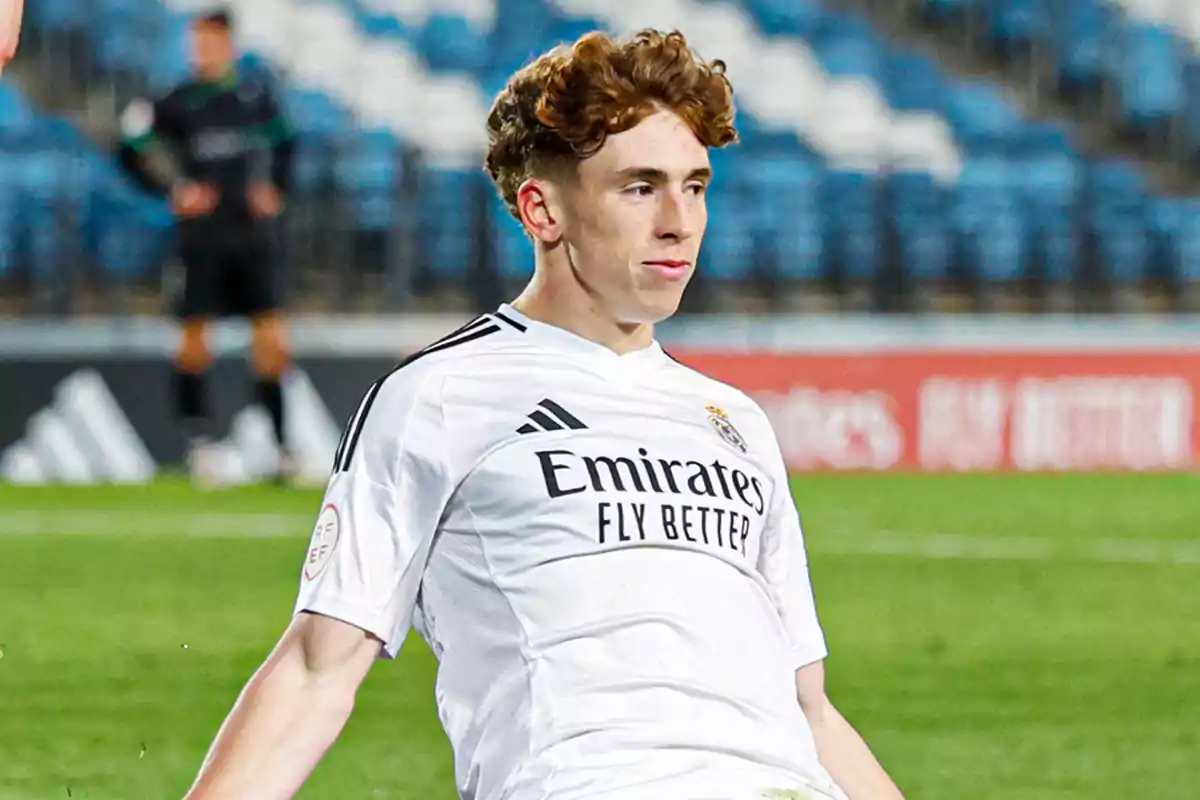 Un jugador de fútbol con uniforme blanco en el campo durante un partido. Un jugador de fútbol con uniforme blanco en el campo durante un partido.