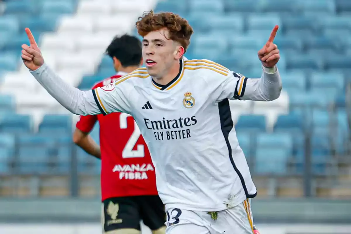 Un jugador de fútbol celebrando un gol con los brazos extendidos en un estadio. Un jugador de fútbol celebrando un gol con los brazos extendidos en un estadio.