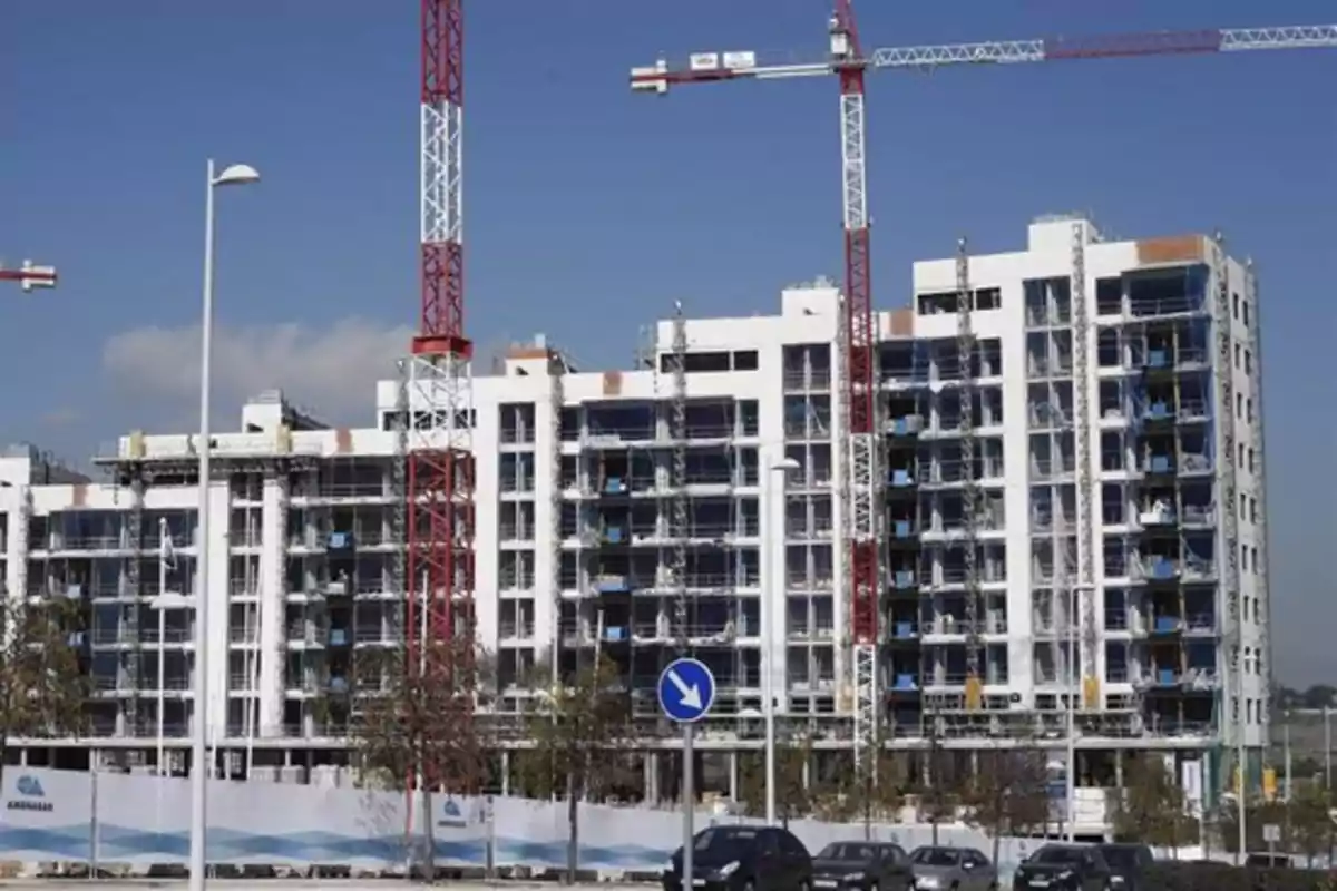 Edificio en construcción con grúas en el sitio y un cielo despejado.