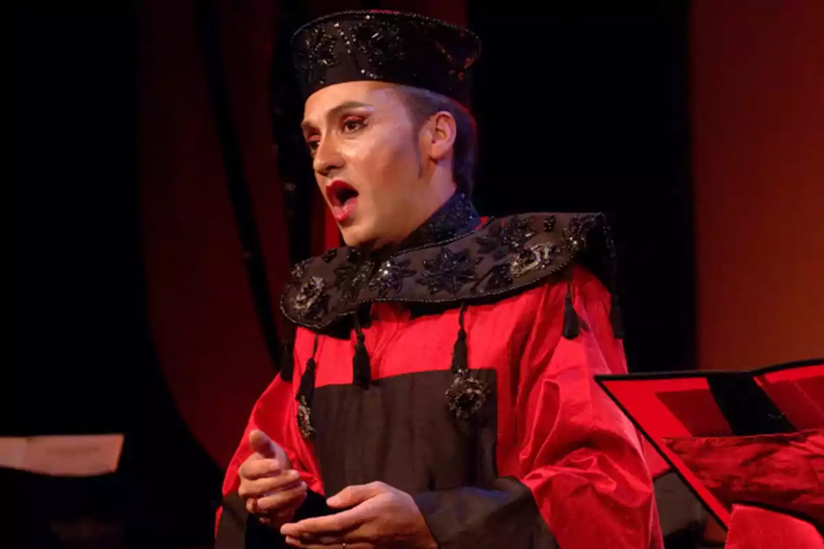 Hombre vestido con un elaborado disfraz rojo y negro cantando en una presentación teatral u operística Hombre vestido con un elaborado disfraz rojo y negro cantando en una presentación teatral u operística