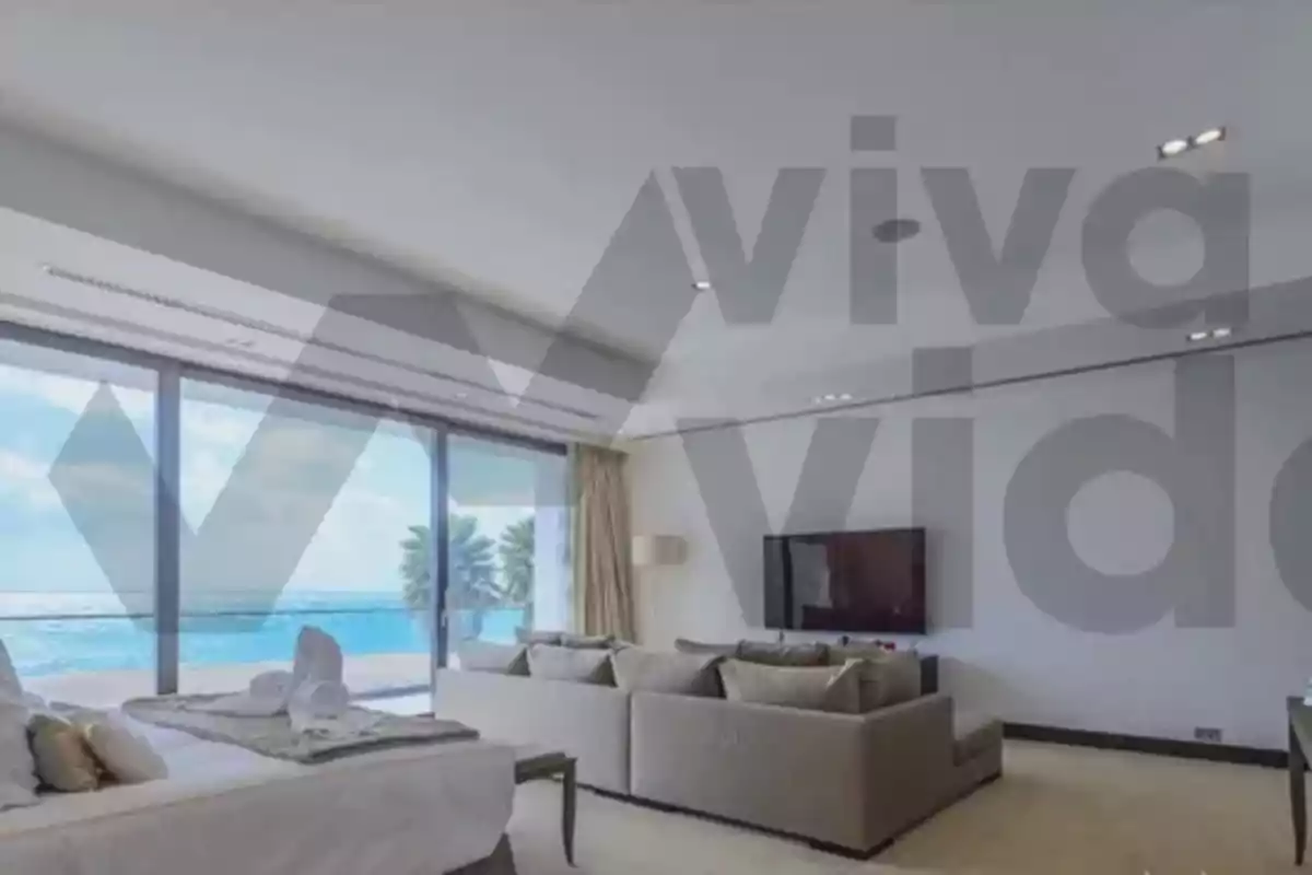 Habitación moderna con vista al mar a través de grandes ventanales y decoración elegante.