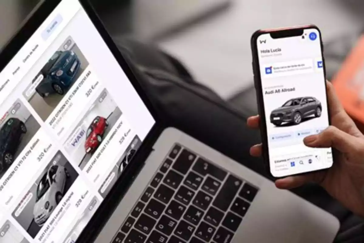 Persona usando una laptop y un teléfono móvil para buscar autos en línea Persona usando una laptop y un teléfono móvil para buscar autos en línea