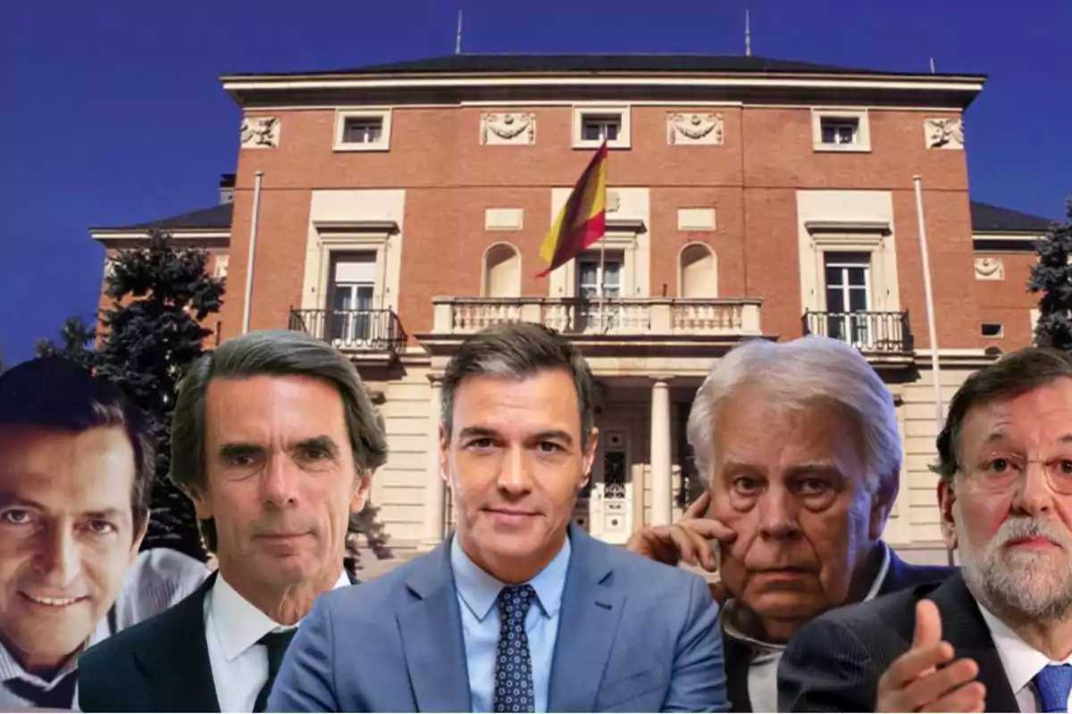 Cinco hombres frente a un edificio gubernamental con una bandera de España.