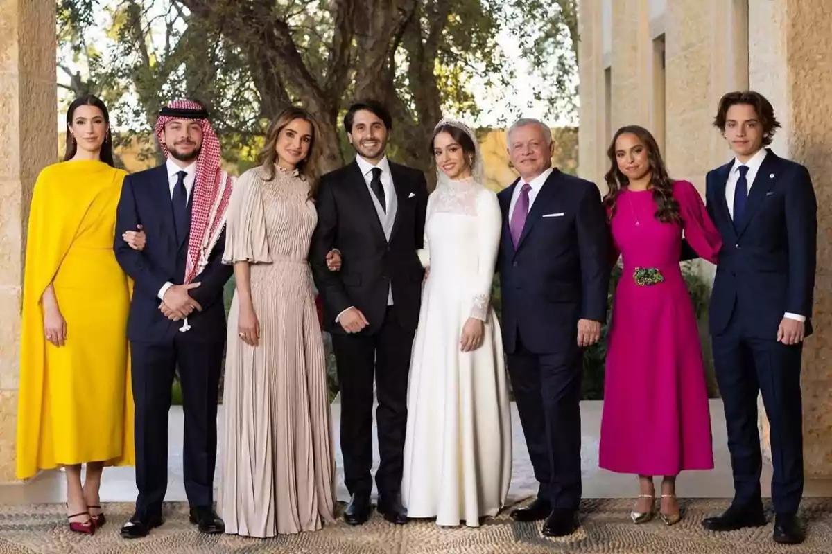 Un grupo de personas elegantemente vestidas posando para una foto en un entorno al aire libre.