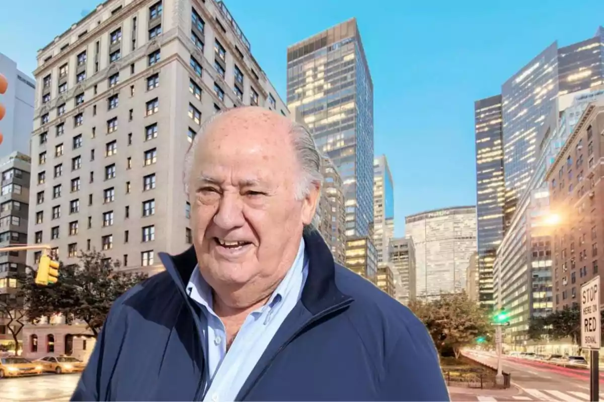 Un hombre mayor con chaqueta azul oscuro y camisa azul claro está sonriendo en una calle de una ciudad con edificios altos y modernos al fondo.