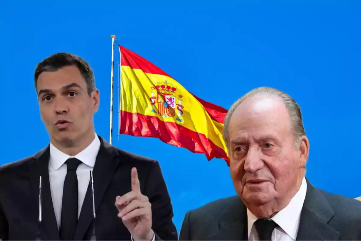 Dos hombres en traje frente a una bandera de España ondeando sobre un cielo azul.