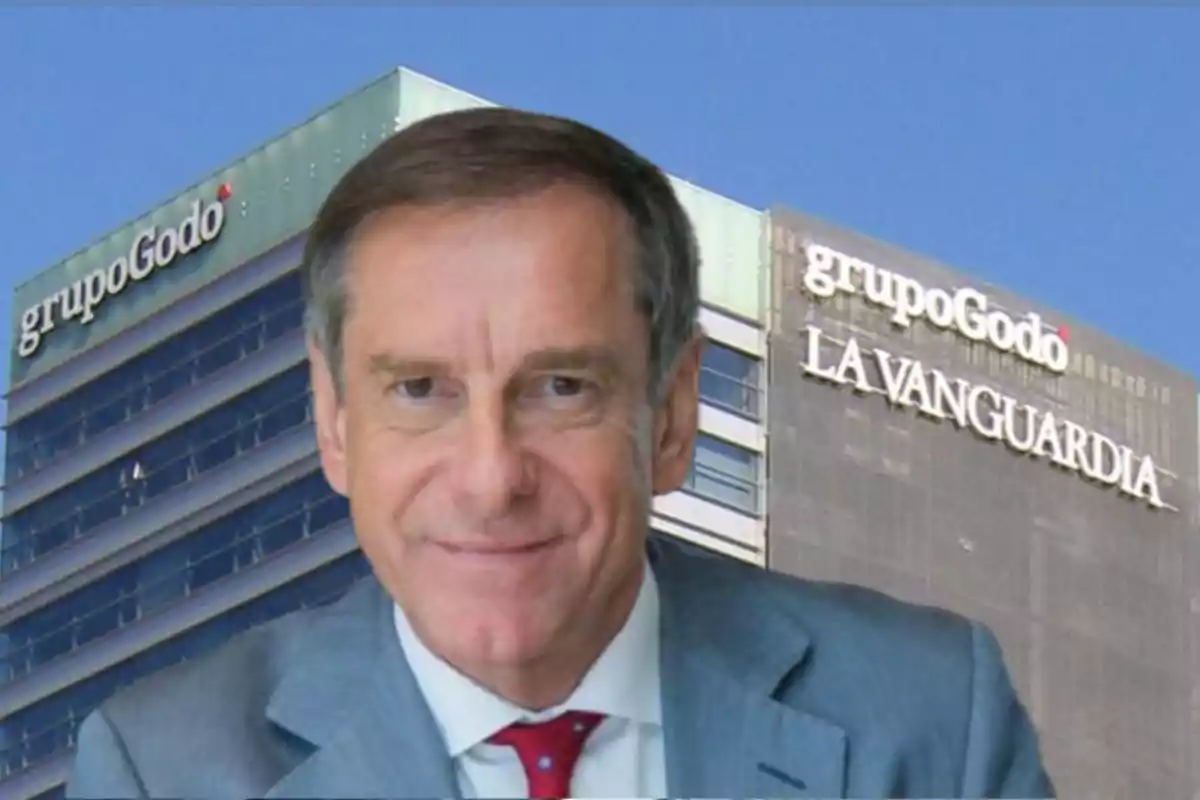 Un hombre con traje frente a un edificio con los logotipos de "grupo Godó" y "La Vanguardia".