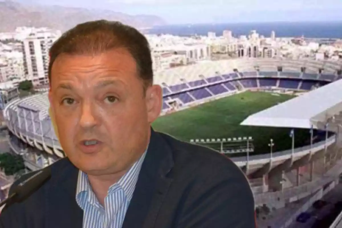 Un hombre hablando frente a un estadio de fútbol.