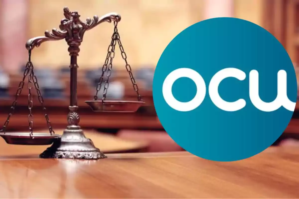 Una balanza de justicia antigua sobre una mesa de madera con un logotipo azul que tiene las letras "OCU".