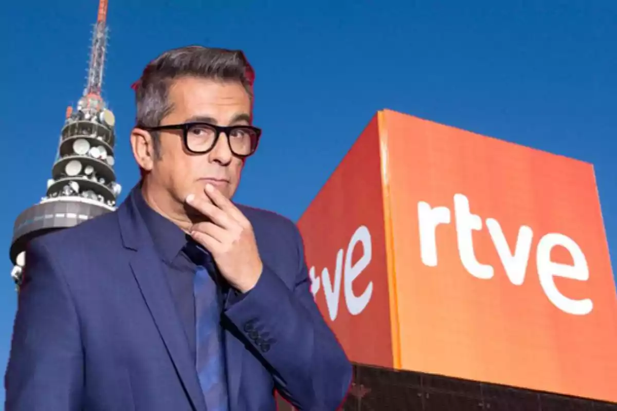 Un hombre con gafas y traje azul está frente a un edificio con el logo de RTVE y una torre de telecomunicaciones al fondo.