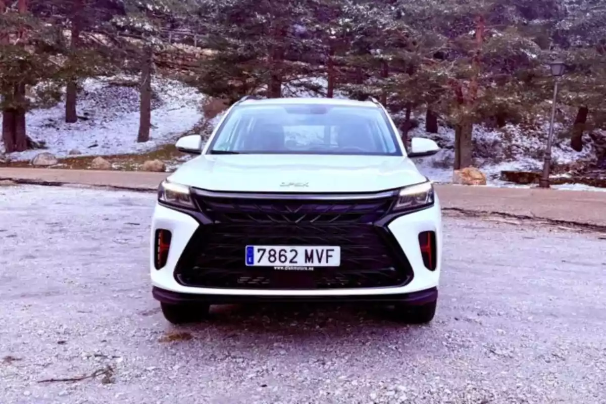 Un DFSK Fengon 600 blanco estacionado en un camino nevado rodeado de árboles. Un DFSK Fengon 600 blanco estacionado en un camino nevado rodeado de árboles.
