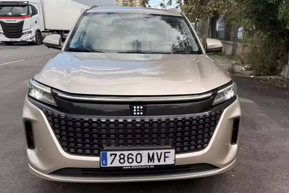 Un DFSK E5 estacionado en una calle con un camión al fondo. Un DFSK E5 estacionado en una calle con un camión al fondo.
