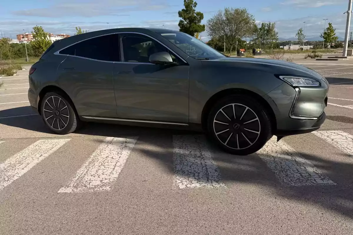 Seres 5 EV gris estacionado sobre un paso de peatones en un aparcamiento al aire libre Seres 5 EV gris estacionado sobre un paso de peatones en un aparcamiento al aire libre