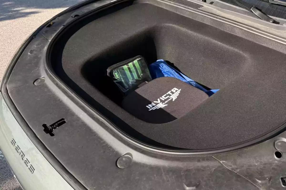 Maletero delantero de un auto eléctrico SERES con una bolsa negra de la marca Invicta y un estuche verde y negro en su interior Maletero delantero de un auto eléctrico SERES con una bolsa negra de la marca Invicta y un estuche verde y negro en su interior