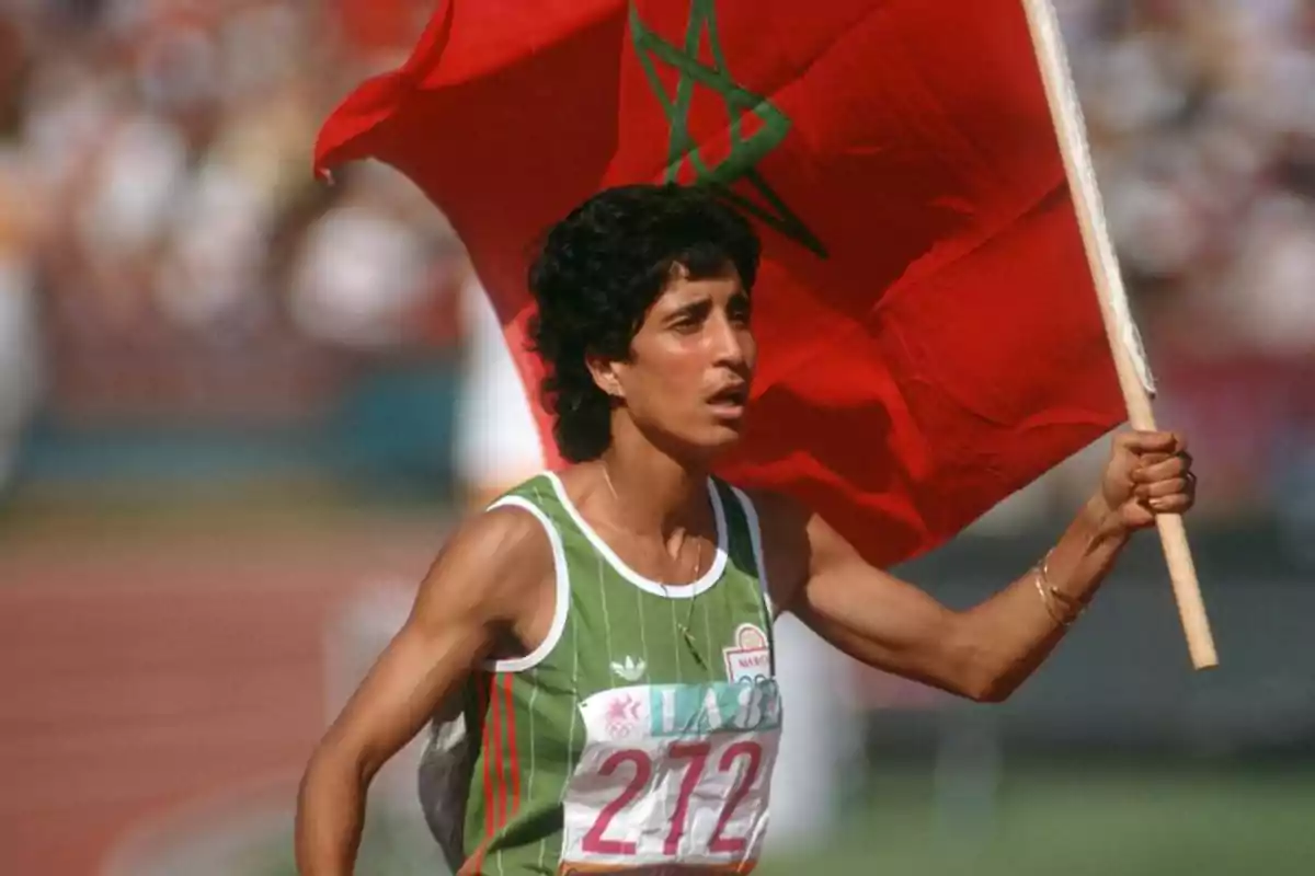 Atleta sosteniendo la bandera de Marruecos durante una competencia.