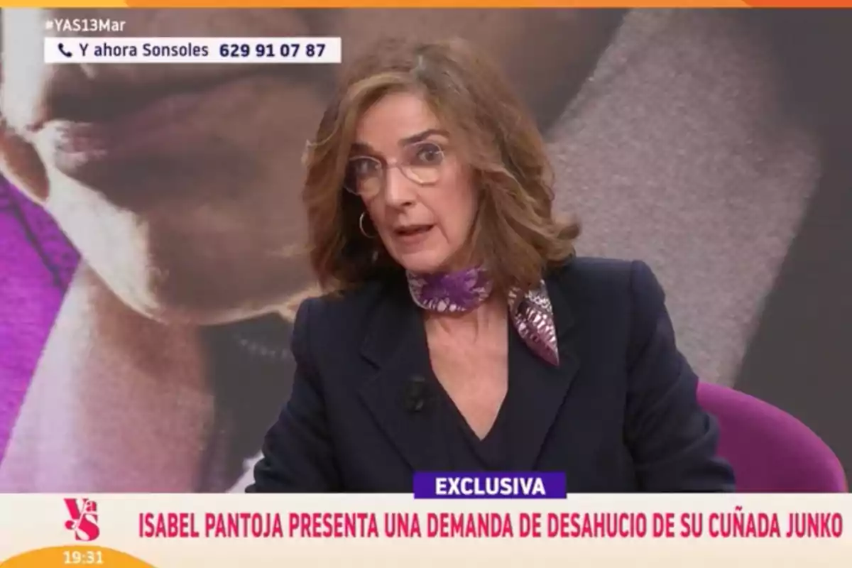 Paloma García-Pelayo con un pañuelo morado está hablando en un programa de televisión que muestra un titular sobre una demanda de desahucio. Captura de 'Y ahora Sonsoles'