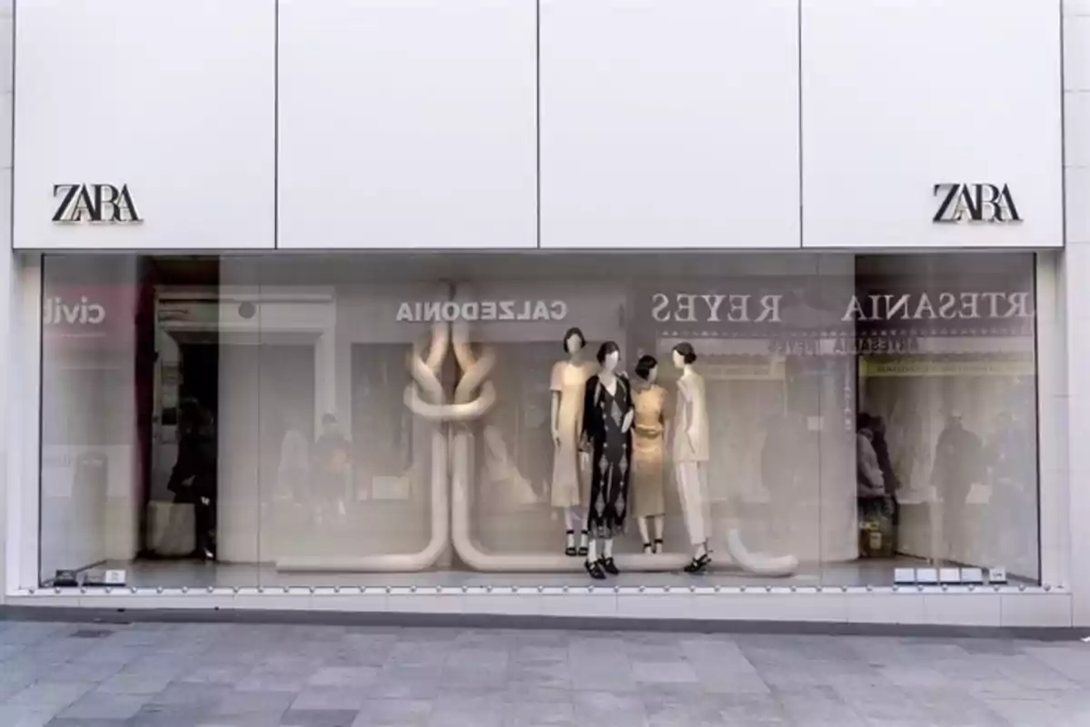Escaparate de una tienda Zara con maniquíes vestidos con ropa elegante y un diseño interior minimalista. Escaparate de una tienda Zara con maniquíes vestidos con ropa elegante y un diseño interior minimalista.