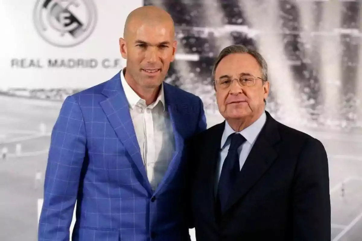 Dos hombres posan juntos frente a un fondo con el logo del Real Madrid.