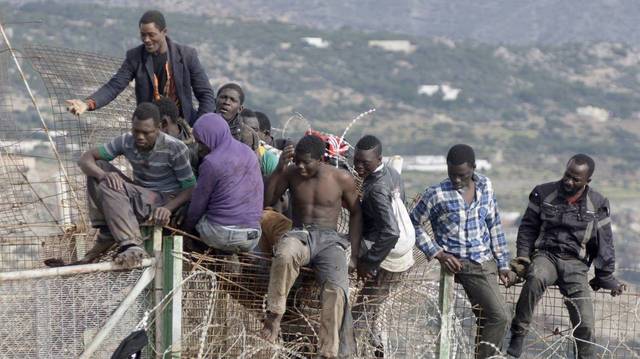 Inmigrantes intentando saltar la valla de Melilla