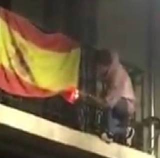 Indignación en Oviedo, un joven trepa a un balcón para quemar una bandera de España 