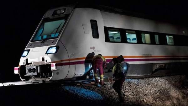 Operarios trabajando en el tren de la línea Madrid-Zafra que descarriló a 500 metros de la estación de Torrijos, en Toledo.