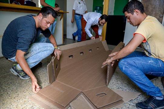 Dos operarios montan un ataúd de cartón reciclado, que se venden por unos cien euros.
