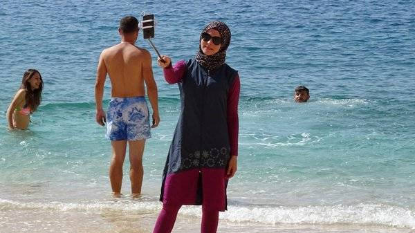 Mujer con Burkini en una playa europea.
