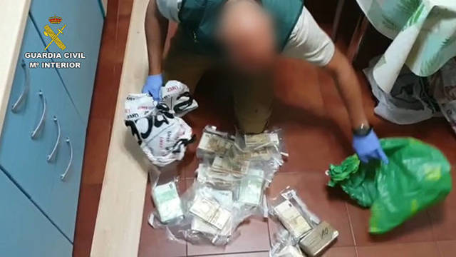Un agente de la Guardia Civil recoge el dinero durante la operación Cansino-Lanas. 
