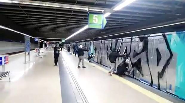 Grafiteros pintando el Metro de Madrid en la estación de Casa de Campo