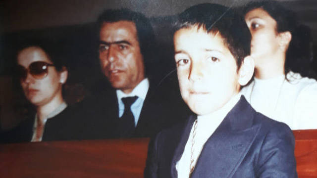 Carlos, el demandante, durante su primera comunión con su padre Juan Galán, detrás.
