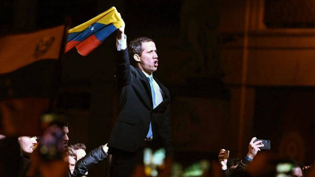 Juan Guaidó en la manifestación de Madrid con una bandera de Venezuela