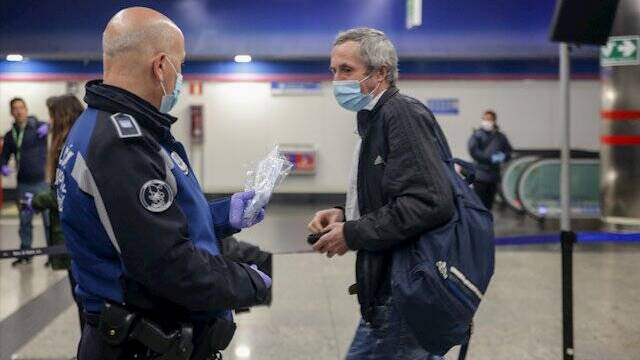 Un Policía Municipal reparte mascarillas en el Metro de Madrid.