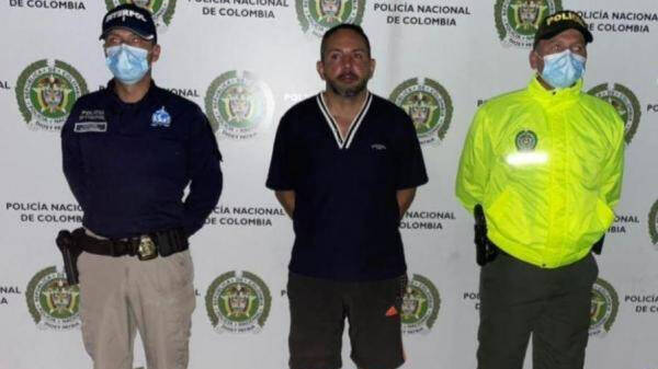 Uno de los detenidos, Gustavo Adolfo Moreno en las instalaciones de la Interpol-Dijín de Colombia acompañado de dos agentes.